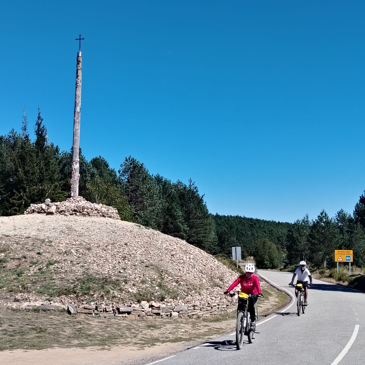 Ciclistas de Ecoaventuras en Bici junto a un mojón del Camino de Santiago